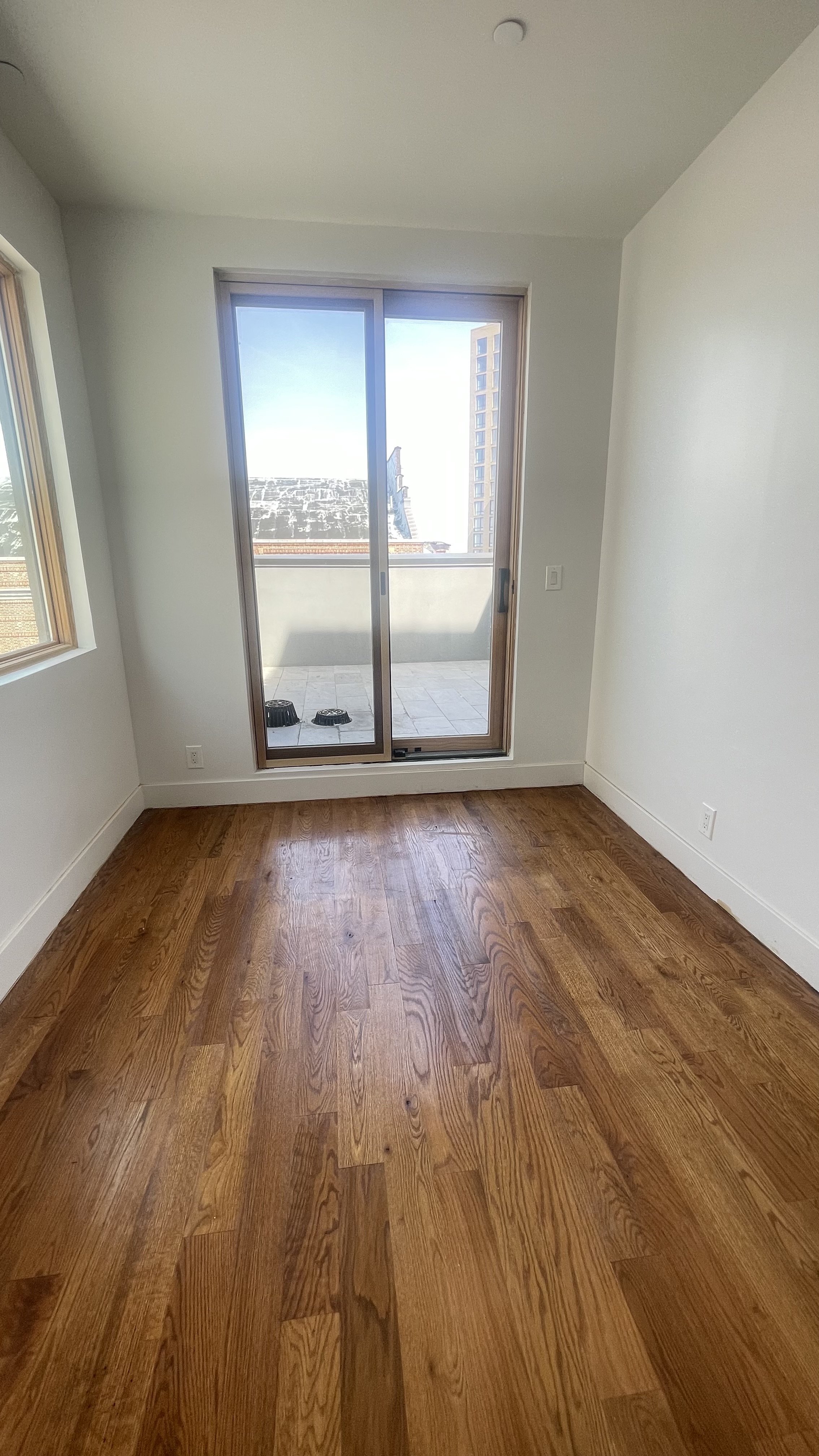 1010 Gates Avenue, Unit 6C Brooklyn, NY 11221 - Photo 3 of 9 a view of an empty room with wooden floor and a window