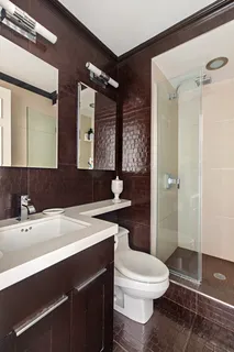 a bathroom with a sink a toilet a mirror and shower