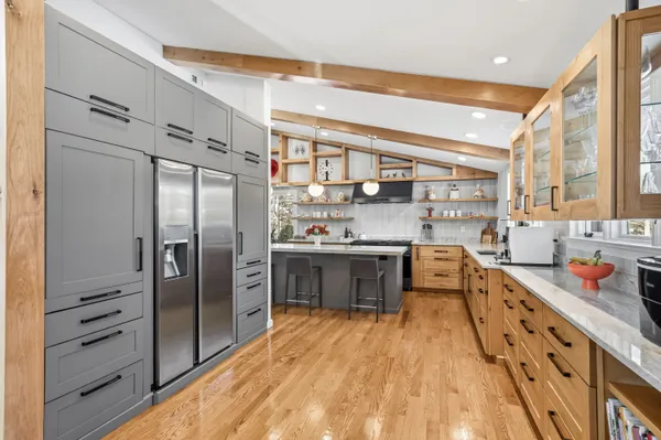 a open kitchen with stainless steel appliances granite countertop a refrigerator a sink dishwasher a stove and white countertops with wooden floor