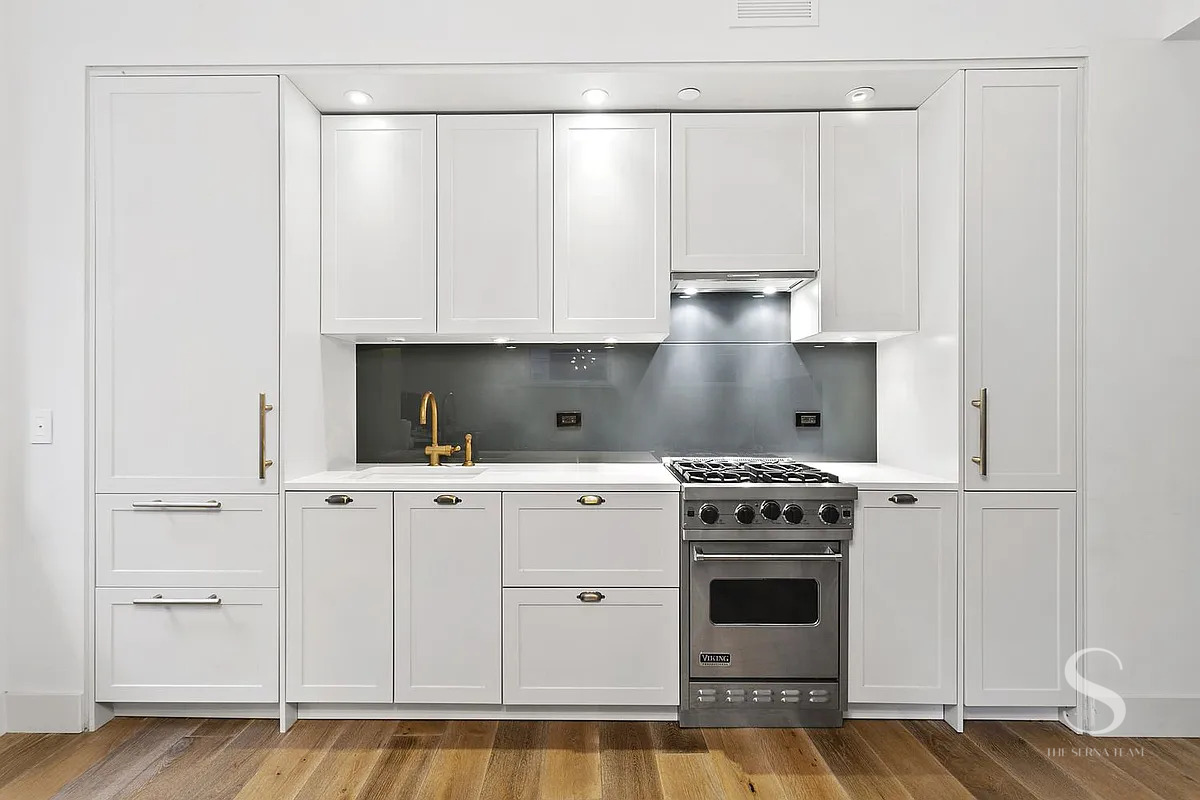 93 Worth Street, Unit 302 Manhattan, NY 10013 - Photo 3 of 10 a kitchen with white cabinets and white appliances