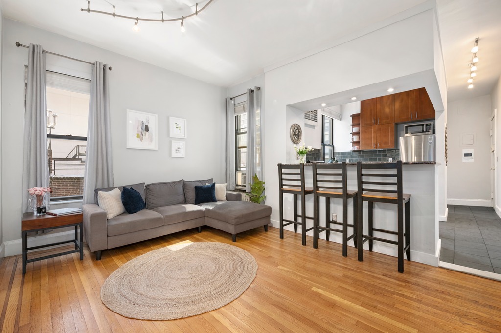 444 East 58th Street, Unit 6C Manhattan, NY 10022 - Photo 2 of 9 a living room with furniture and a wooden floor