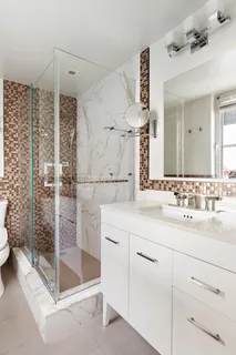 a bathroom with a shower sink and mirror