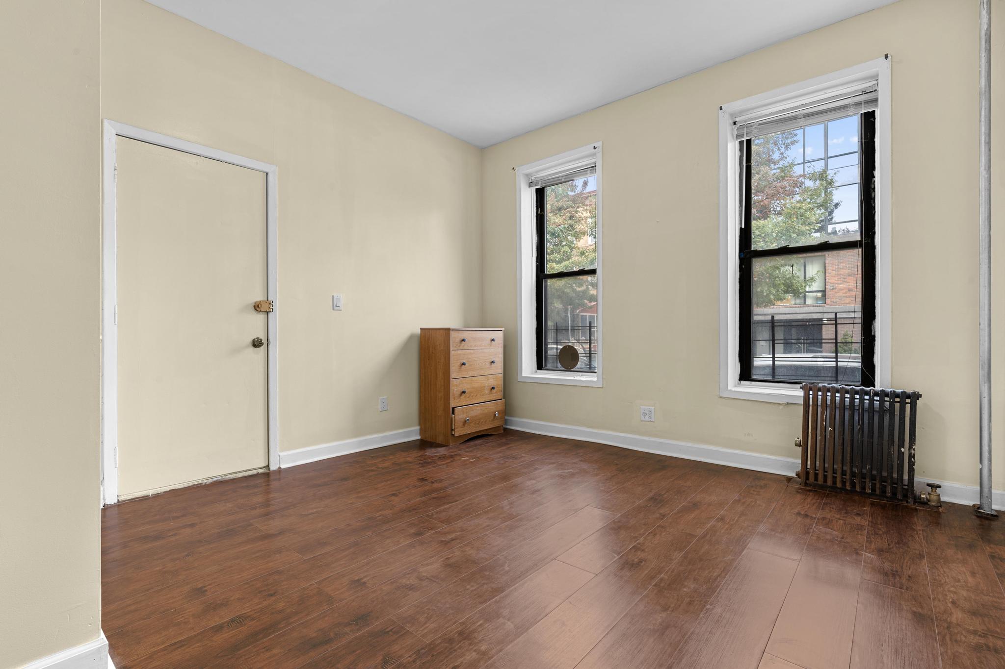 1328 Herkimer Street, Unit 1 Brooklyn, NY 11233 - Photo 6 of 9 an empty room with windows and closet