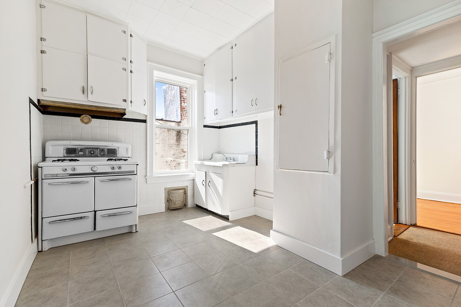 4401 4th Avenue, Unit D4 Brooklyn, NY 11220 - Photo 5 of 7 a kitchen with white cabinets and white appliances