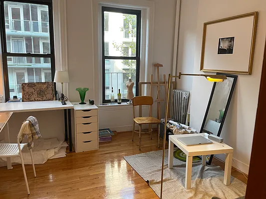 a living room with furniture a window and wooden floor