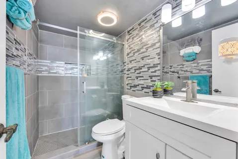 a bathroom with a sink a toilet and shower