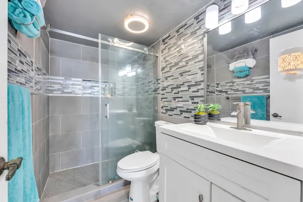 a bathroom with a sink a toilet and shower