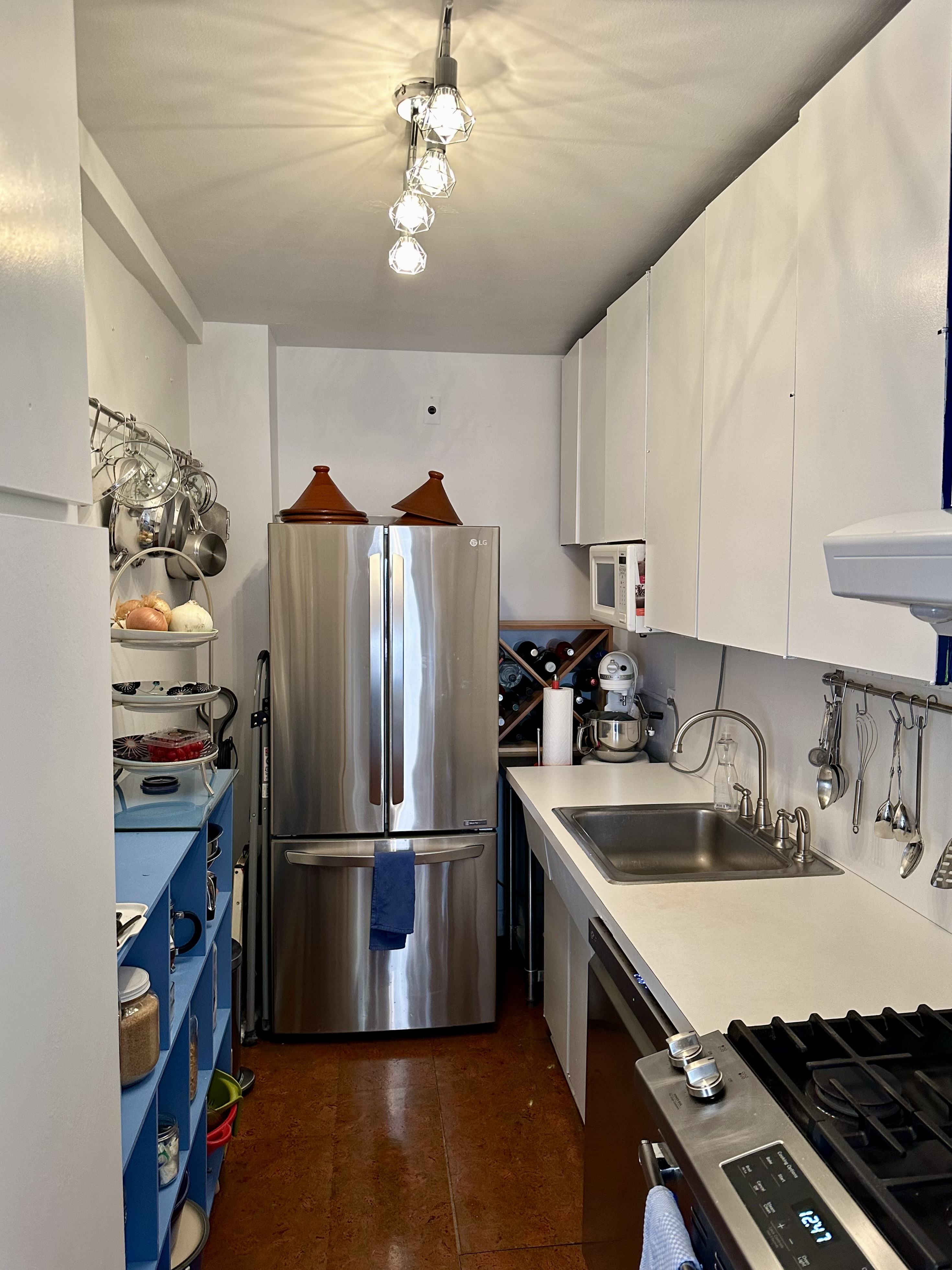 347 East 53rd Street, Unit 2B Manhattan, NY 10022 - Photo 4 of 7 a kitchen with stainless steel appliances granite countertop a sink stove and refrigerator