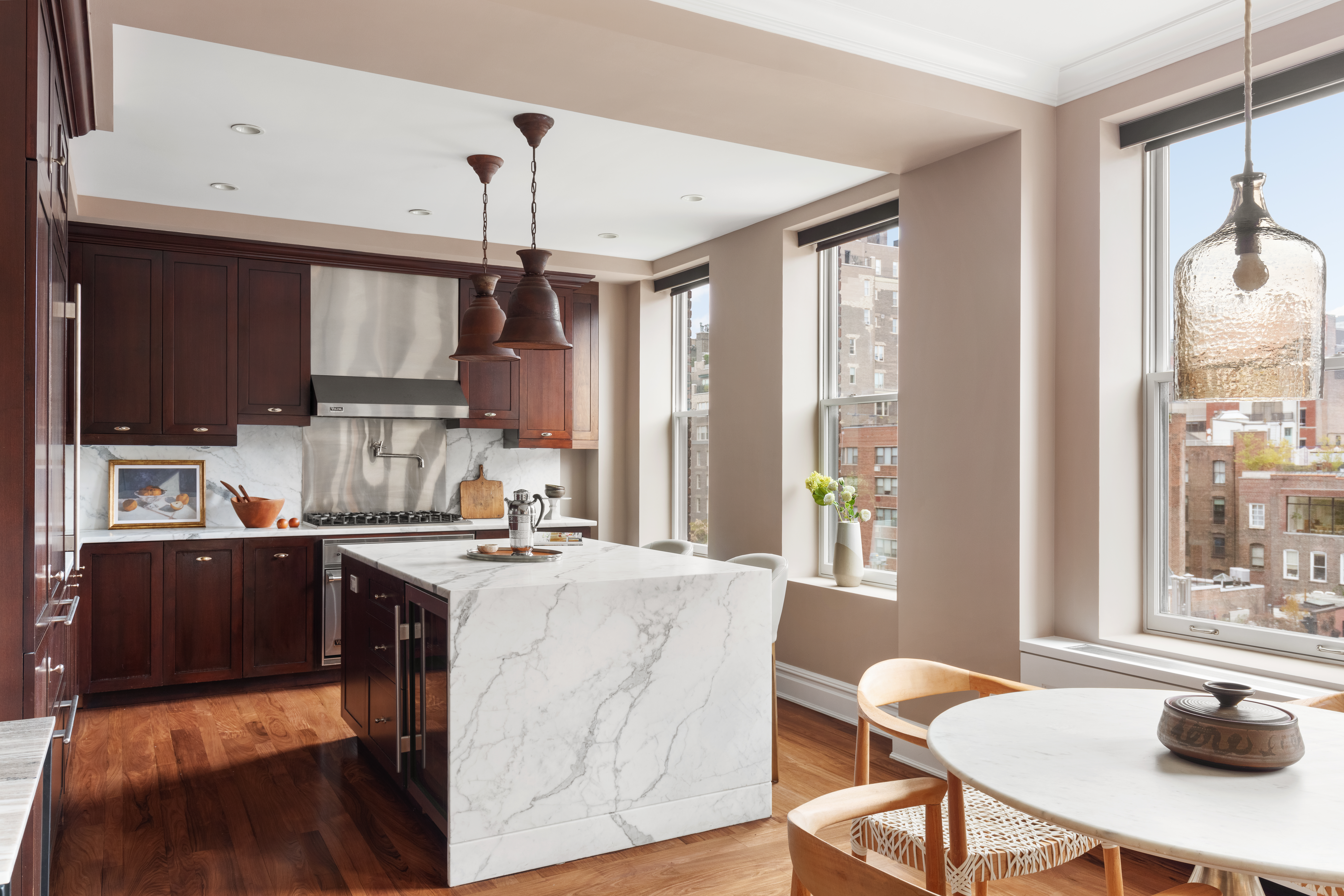 31 West 11th Street Manhattan, NY 10011 - Photo 6 of 21 a kitchen with stainless steel appliances granite countertop a stove a sink dishwasher a dining table and chairs with wooden floor