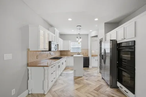 a kitchen with stainless steel appliances granite countertop a refrigerator and a sink