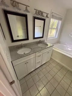 a bathroom with a double vanity sink mirror and toilet