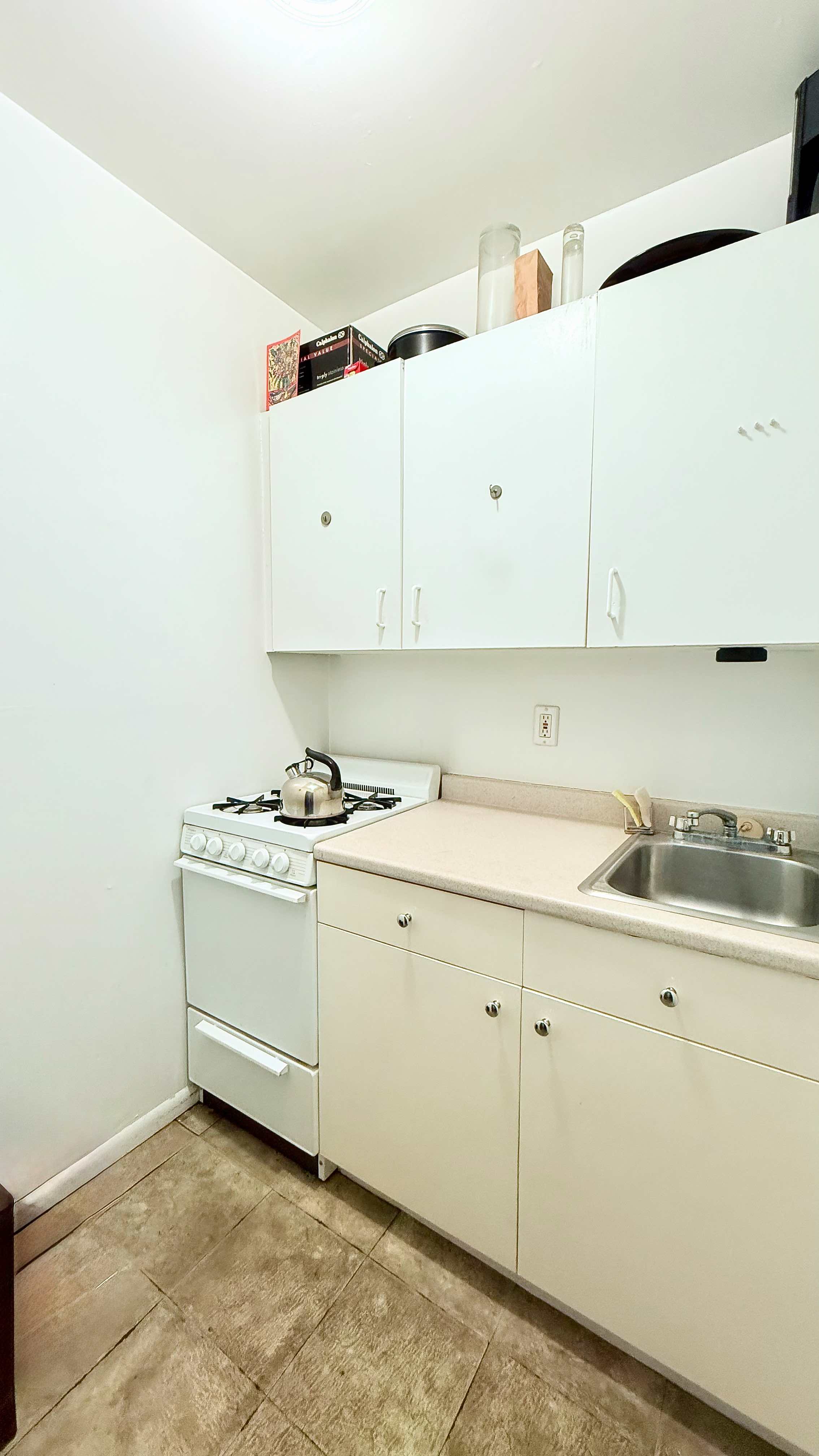 229 East 29th Street, Unit 5H Manhattan, NY 10016 - Photo 3 of 15 a kitchen with granite countertop white cabinets and white appliances