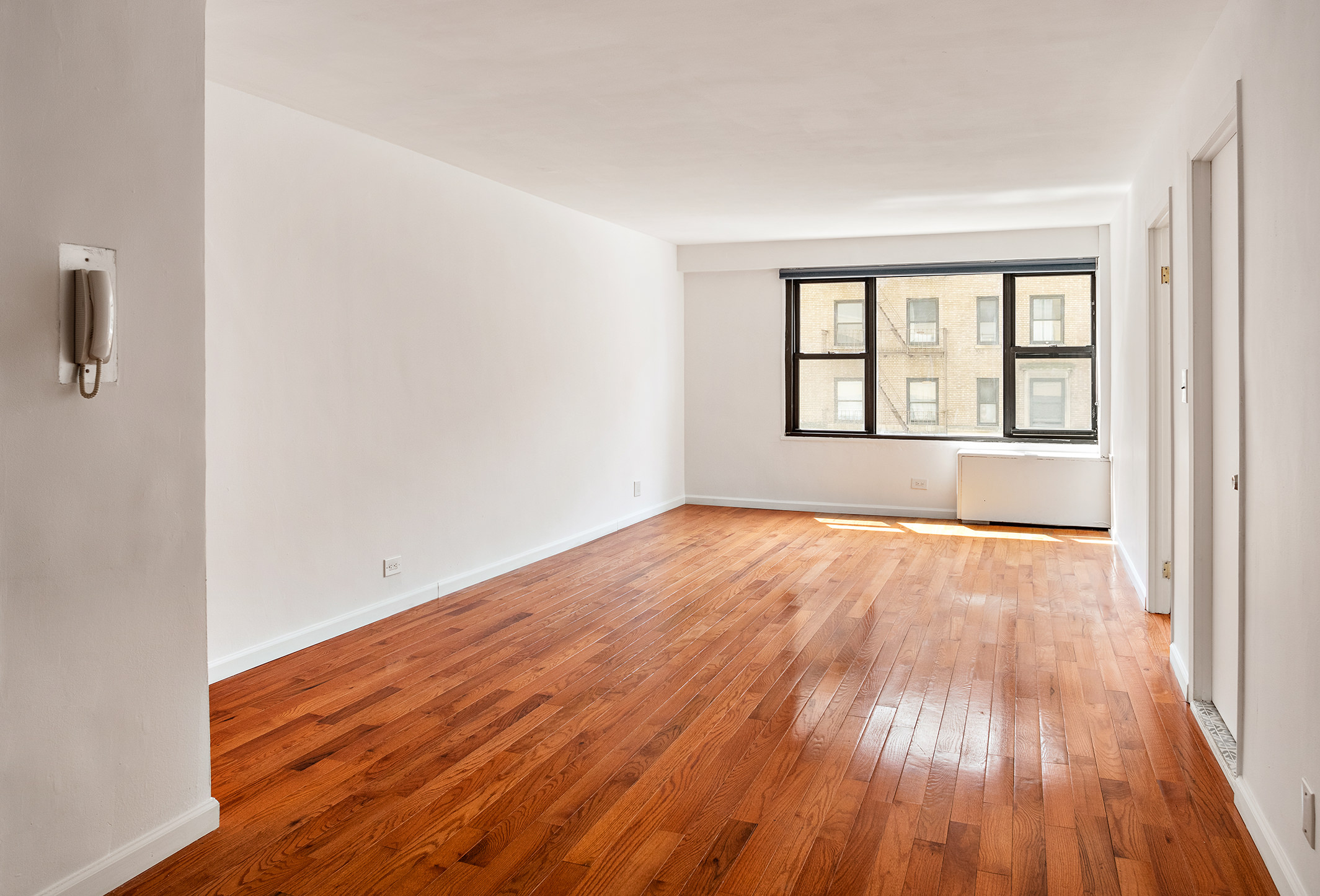 85 Livingston Street, Unit 3H Brooklyn, NY 11201 - Photo 2 of 9 an empty room with wooden floor and windows
