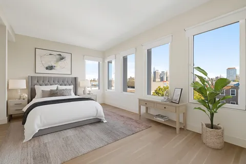a bedroom with a bed a potted plant and dresser