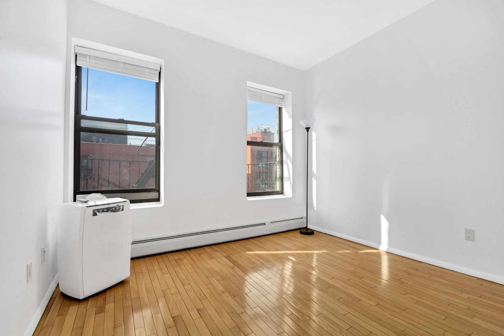 277 Nostrand Avenue, Unit 3A Brooklyn, NY 11216 - Photo 5 of 10 an empty room with wooden floor and windows