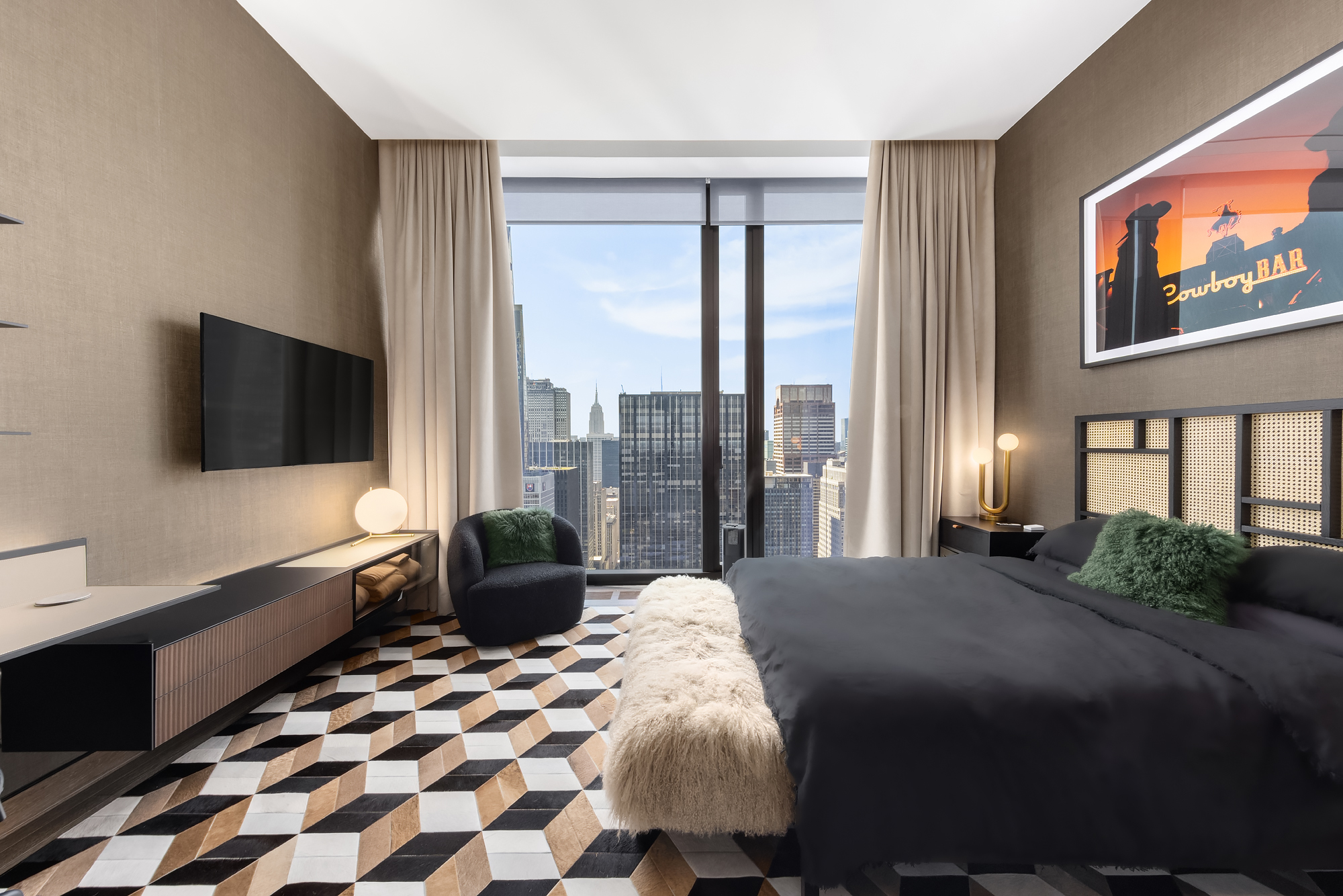 111 West 57th Street, Unit 46 Manhattan, NY 10019 - Photo 10 of 14 a bedroom with a bed and a flat tv screen on dresser