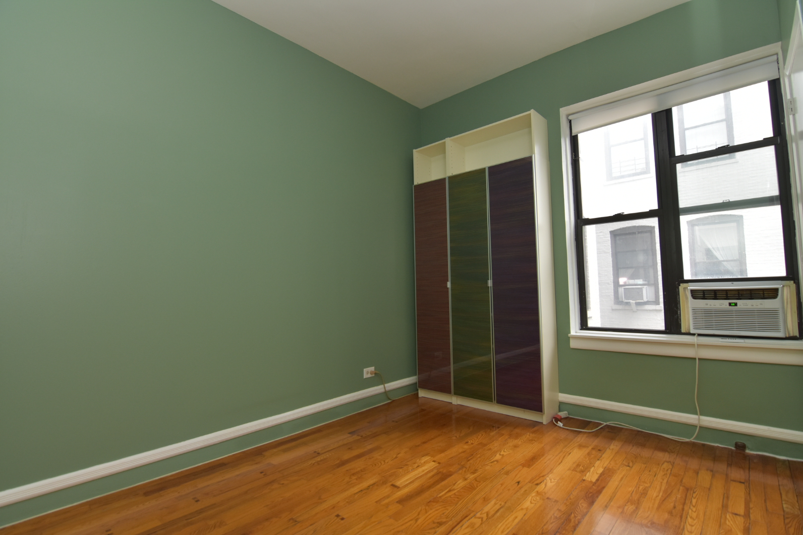 668 Riverside Drive, Unit 5A Manhattan, NY 10031 - Photo 3 of 8 an empty room with wooden floor and windows