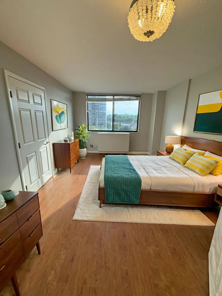 a bedroom with a large bed and a chandelier