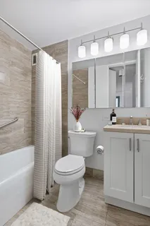 a bathroom with a sink a toilet a mirror a vanity and bathtub