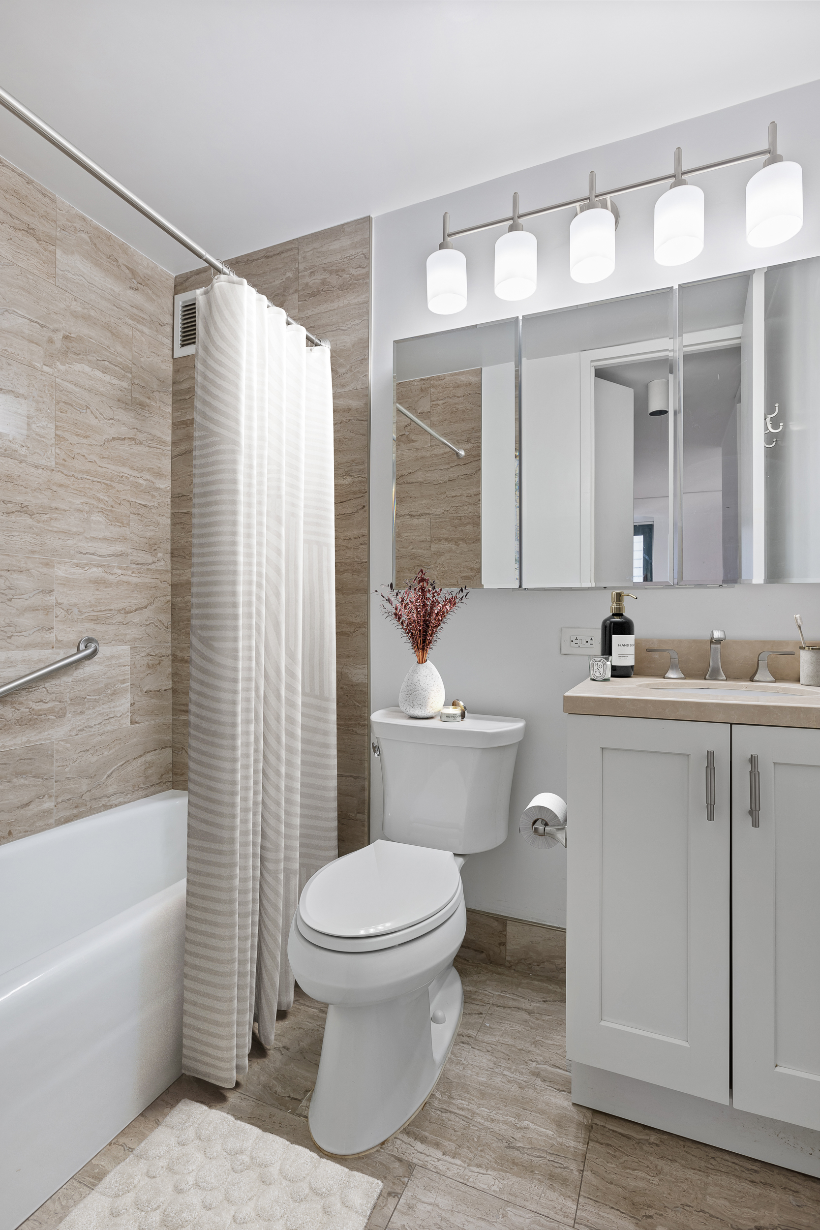 1 Irving Place, Unit G7G Manhattan, NY 10003 - Photo 7 of 8 a bathroom with a sink a toilet a mirror a vanity and bathtub