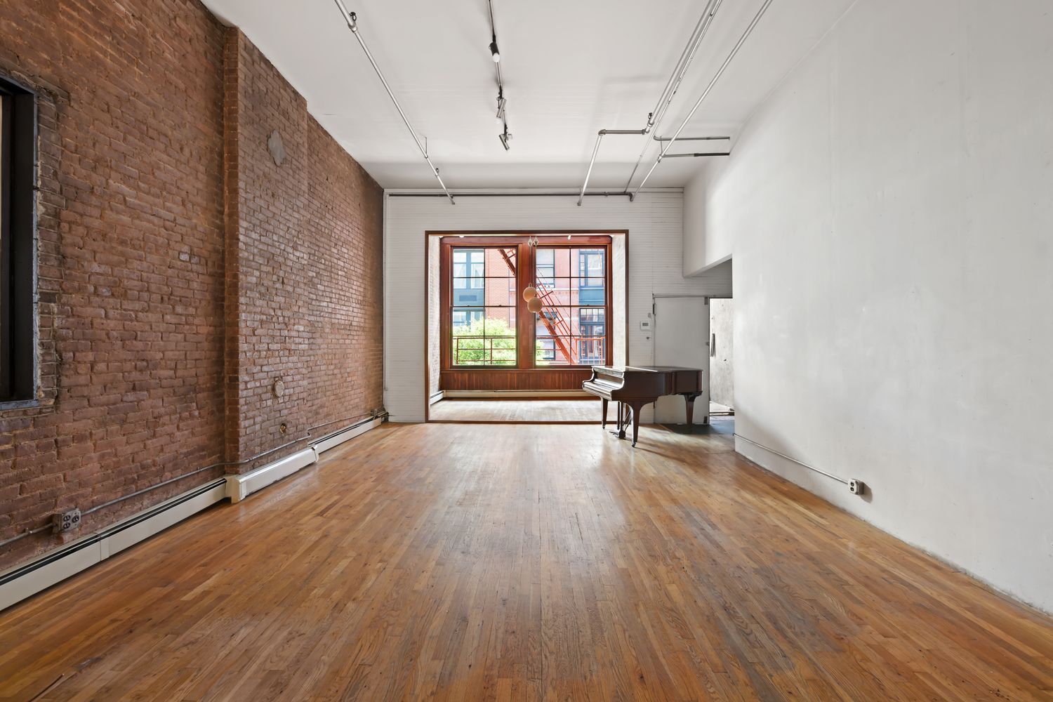 a view of a room with wooden floor and a window