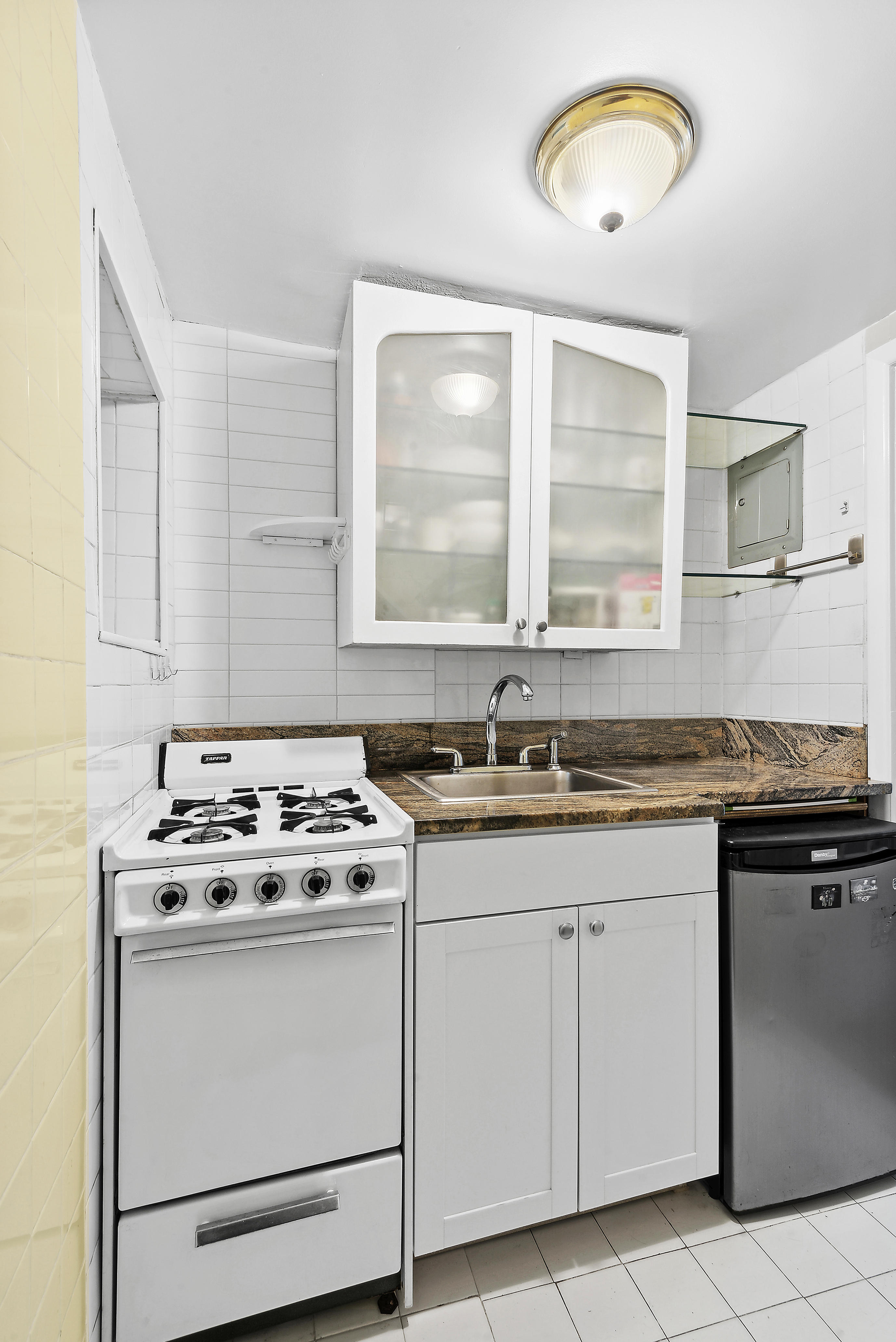 309 West 20th Street, Unit 1R Manhattan, NY 10011 - Photo 6 of 10 a kitchen with cabinets appliances a sink and a window