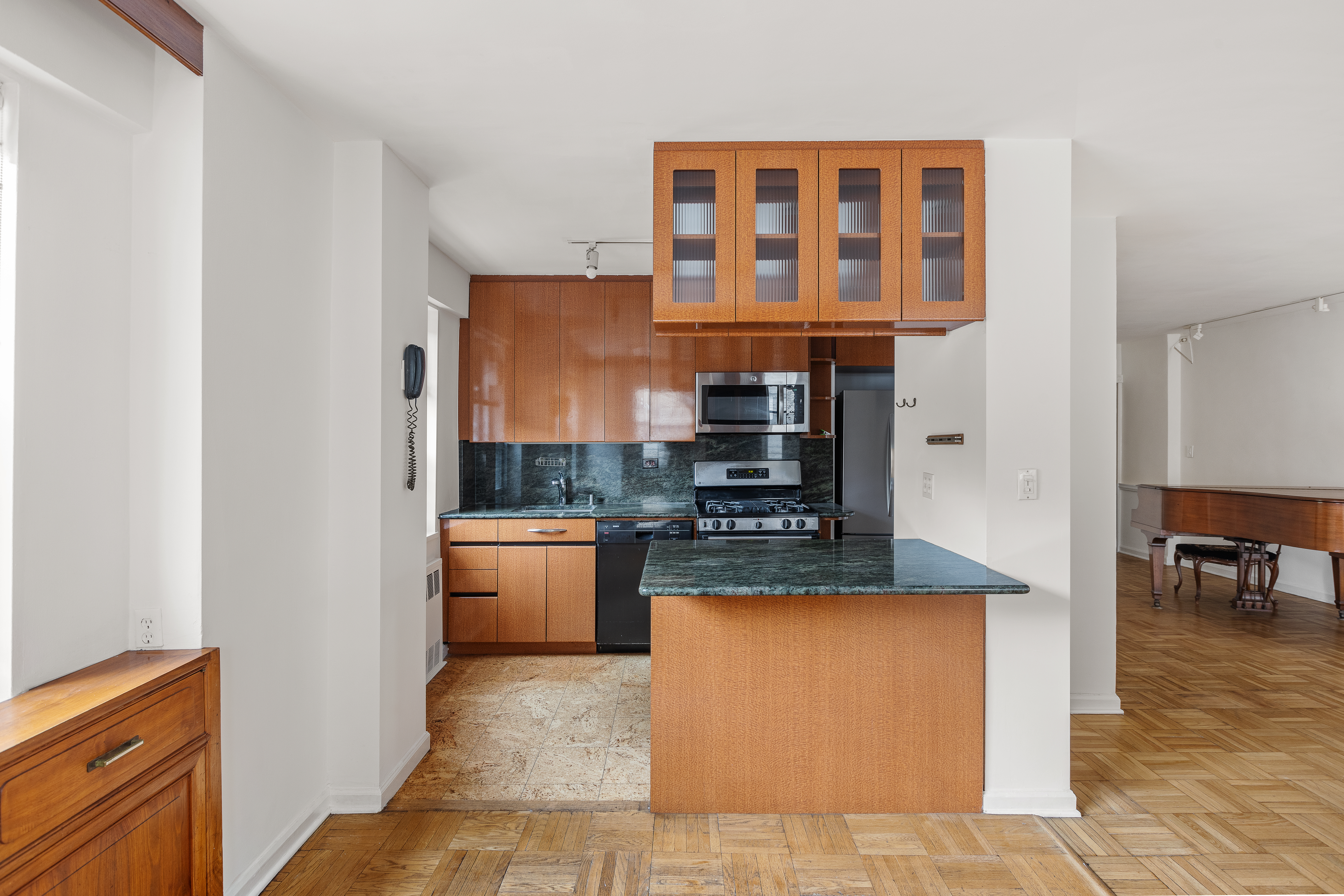 70 East 10th Street, Unit 3M Manhattan, NY 10003 - Photo 3 of 14 a large kitchen with stainless steel appliances granite countertop a stove and a sink