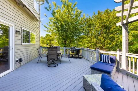 a balcony with wooden floor and outdoor seating