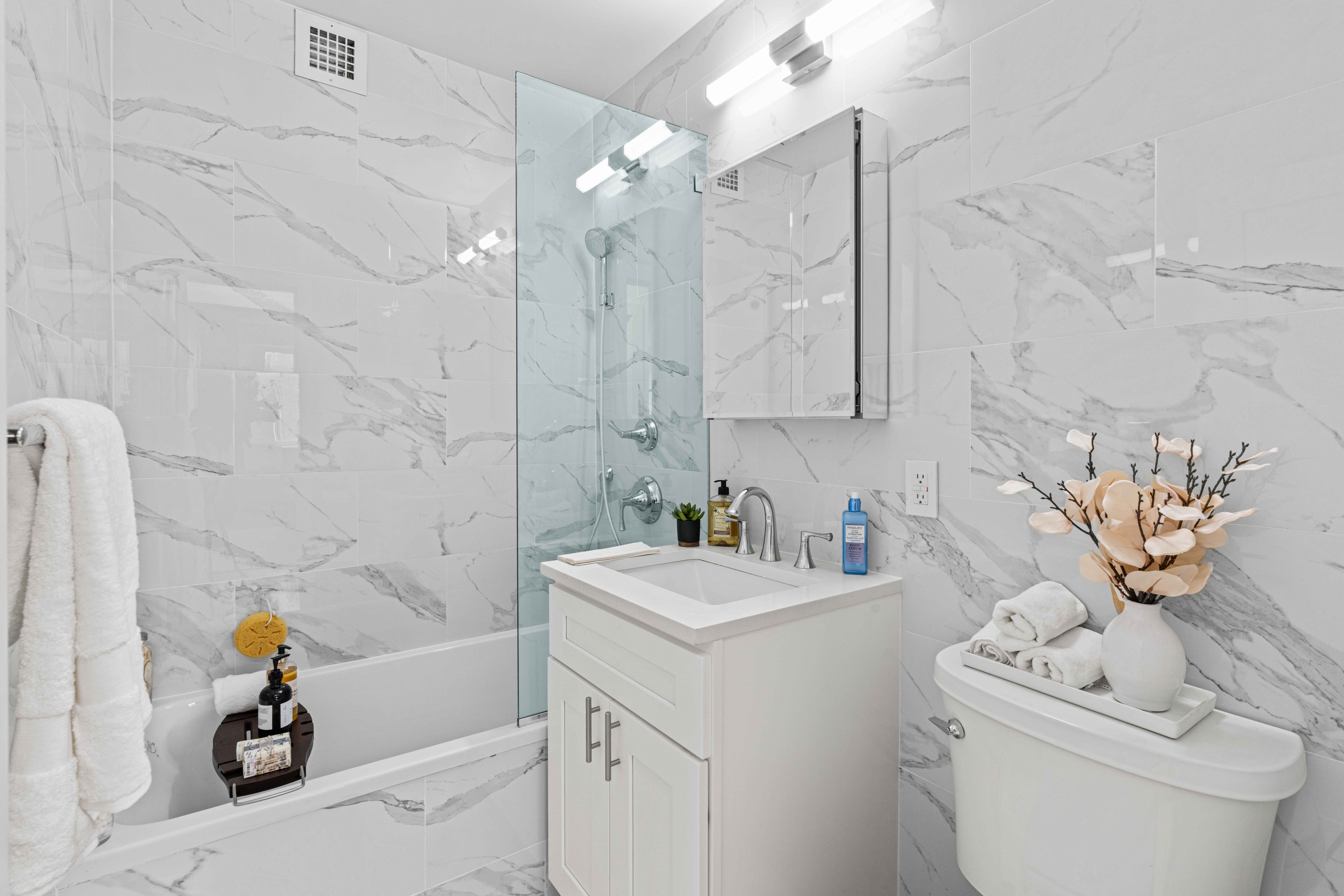 400 East 54th Street, Unit 22D Manhattan, NY 10022 - Photo 13 of 21 a bathroom with a sink a toilet and shower