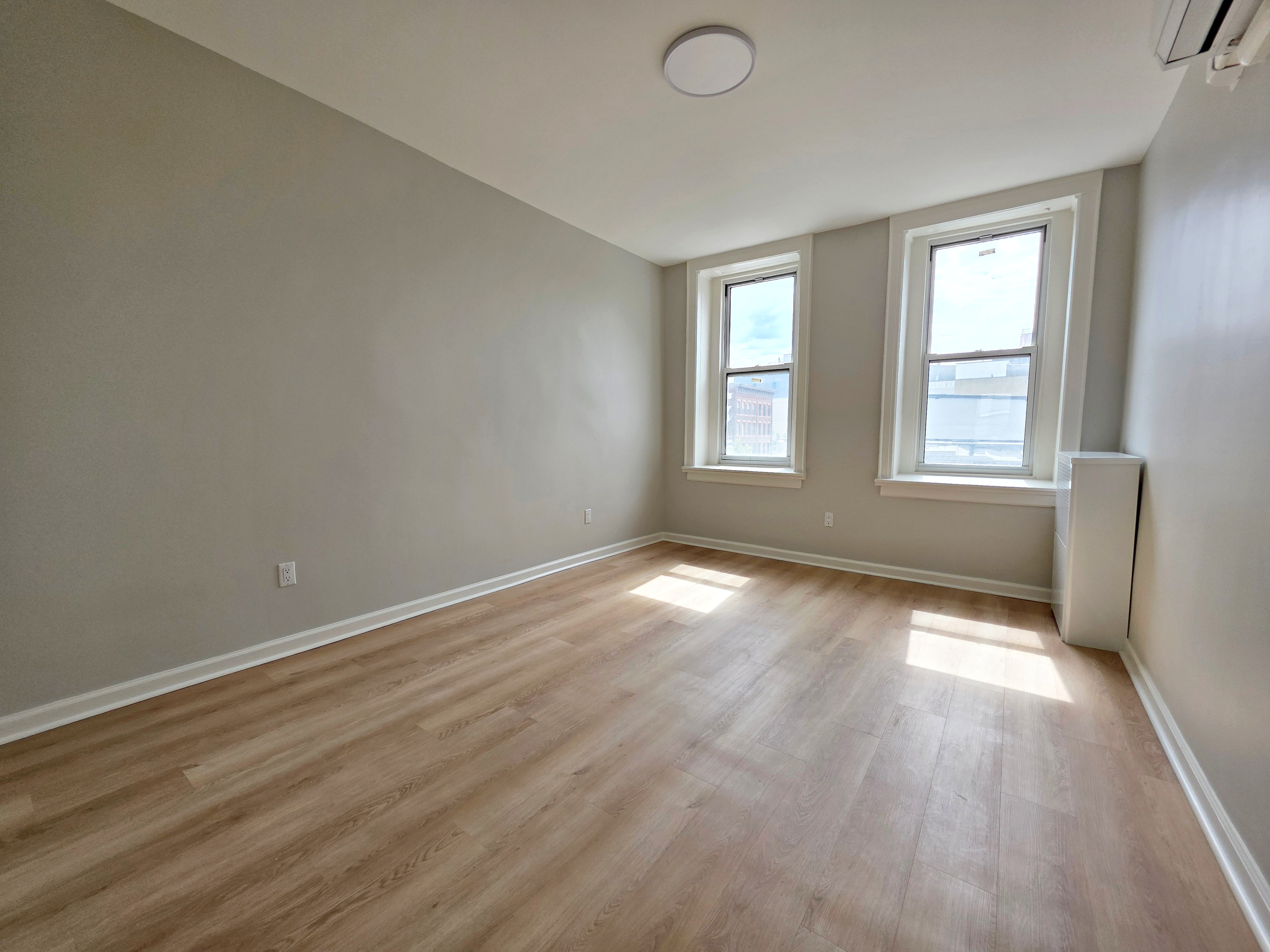 733 Metropolitan Avenue, Unit 3 Brooklyn, NY 11211 - Photo 9 of 13 an empty room with wooden floor and windows