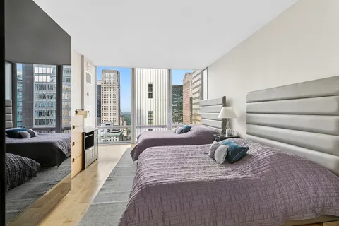 a large bedroom with a bed and glass windows
