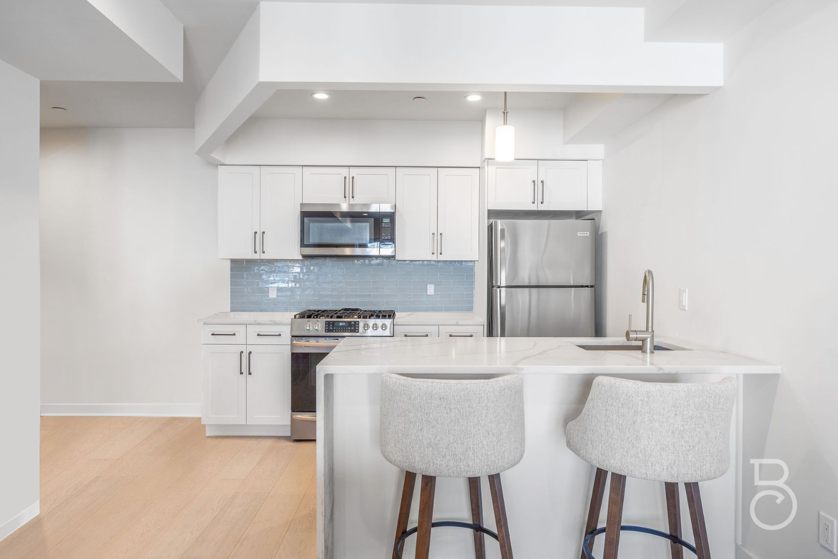 25-74 34th Street, Unit 4C Queens, NY 11103 - Photo 7 of 15 a kitchen with kitchen island granite countertop a sink cabinets and refrigerator
