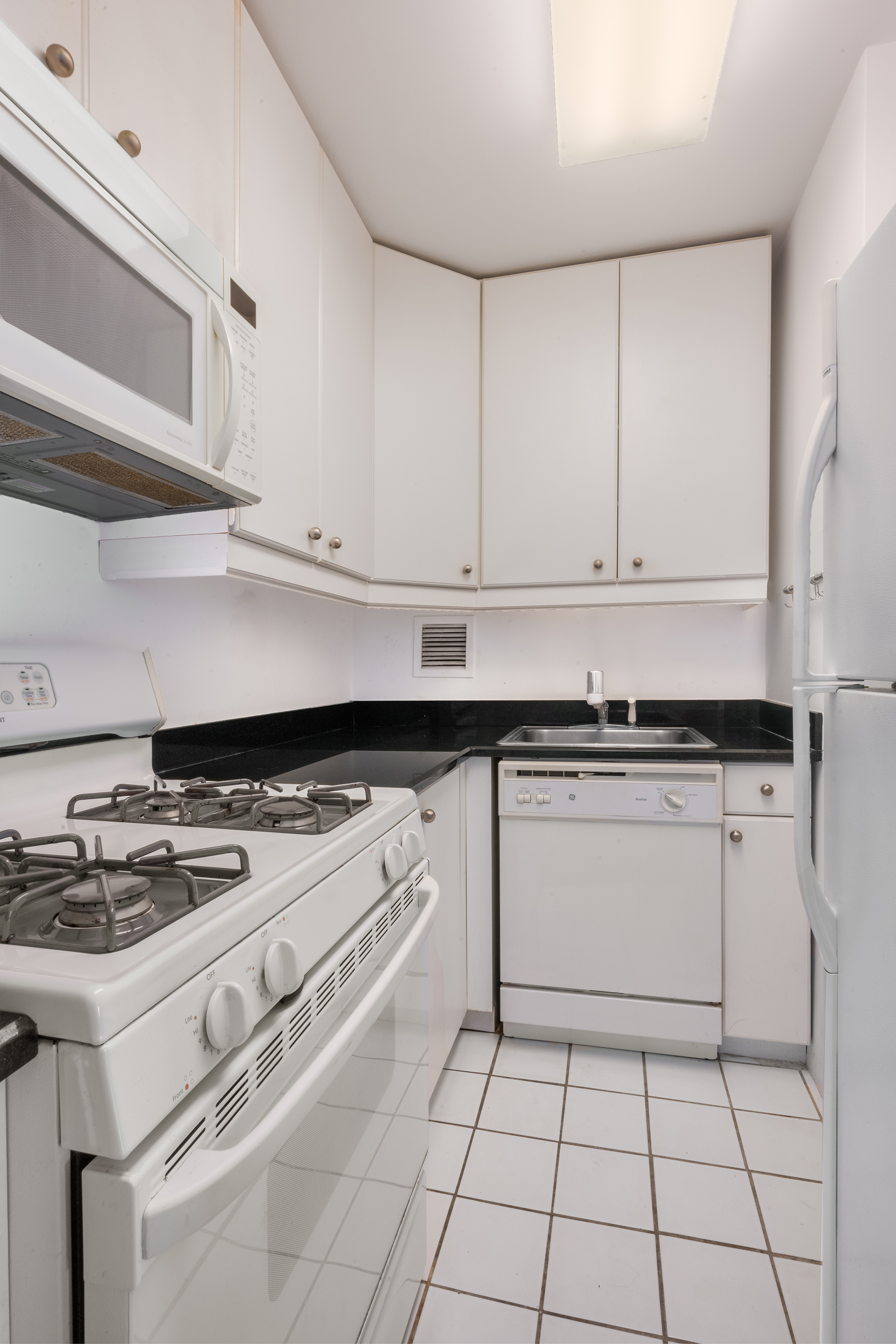 330 East 38th Street, Unit 41H Manhattan, NY 10016 - Photo 4 of 6 a white stove top oven sitting inside of a kitchen