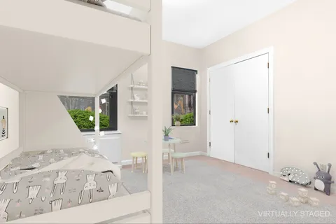 a view of a bedroom with a bed and wooden floor