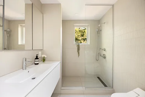 a bathroom with a sink a toilet and shower