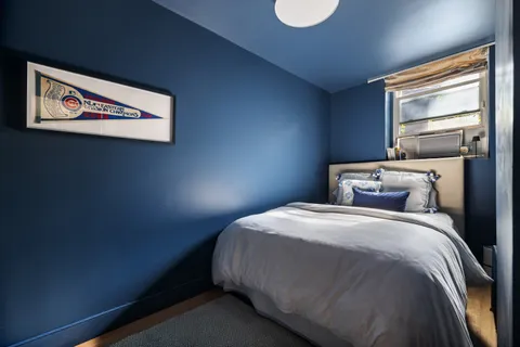 a bed sitting in a bedroom next to a window