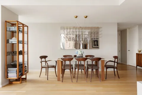 a view of a a dining room with furniture window and wooden floor