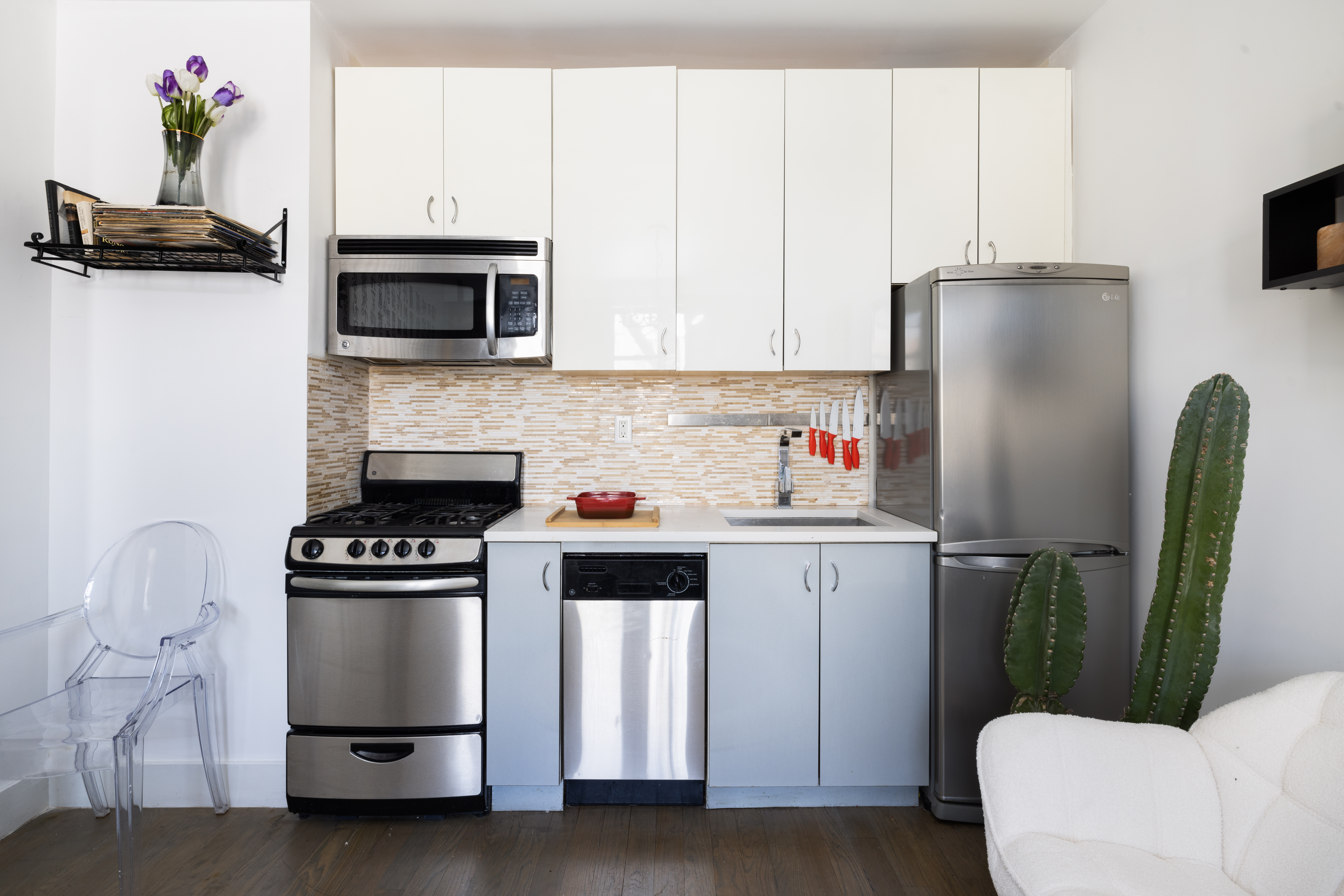 48 West 138th Street, Unit 5J Manhattan, NY 10037 - Photo 3 of 13 a kitchen with stainless steel appliances a refrigerator a stove a microwave and cabinets