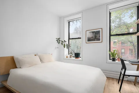 a bedroom with a bed and a painting on the wall