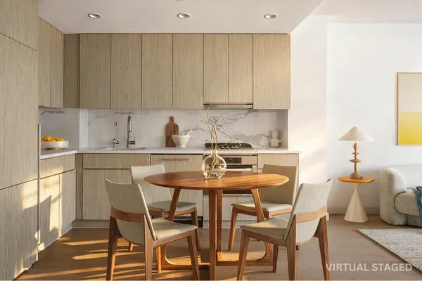 a kitchen with a dining table chairs and white cabinets