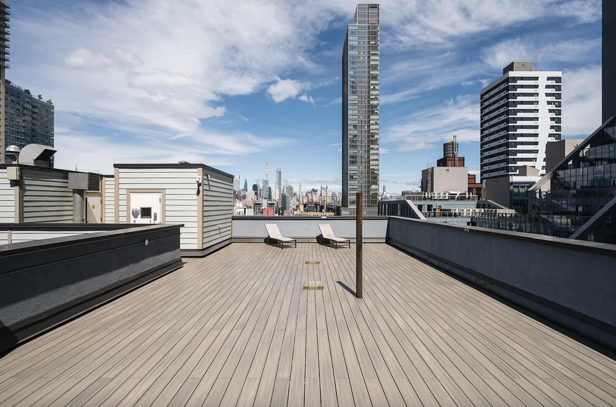 42-37 27th Street, Unit 8B Queens, NY 11101 - Photo 6 of 11 a balcony with wooden floor and outdoor seating