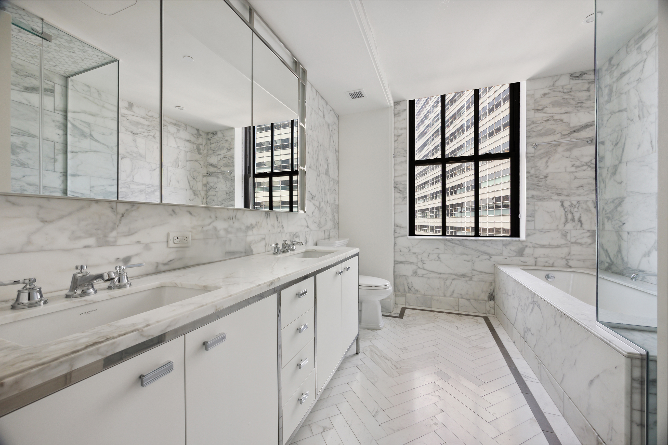 100 Barclay Street, Unit 15B Manhattan, NY 10007 - Photo 10 of 16 a spacious bathroom with a double vanity sink a mirror and a bathtub