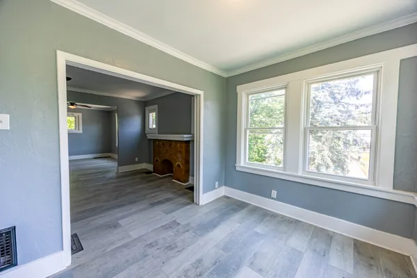 an empty room with windows and fan