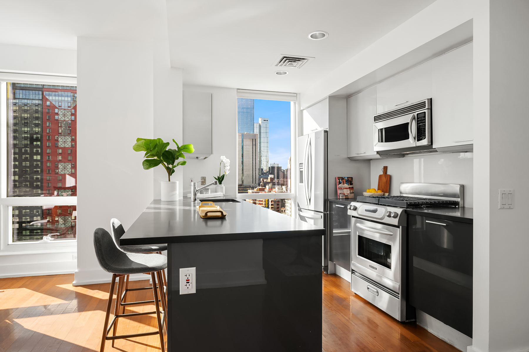 350 West 42nd Street, Unit 20G Manhattan, NY 10036 - Photo 5 of 27 a kitchen with stainless steel appliances granite countertop a stove a sink and a refrigerator