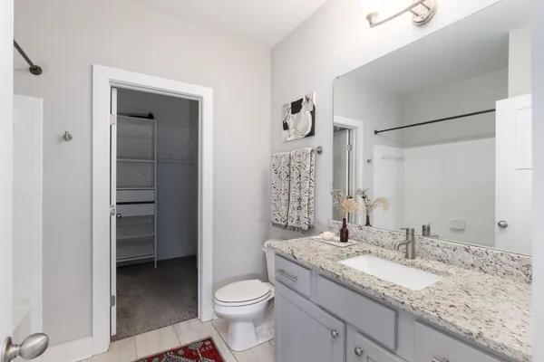a bathroom with a granite countertop sink toilet and shower