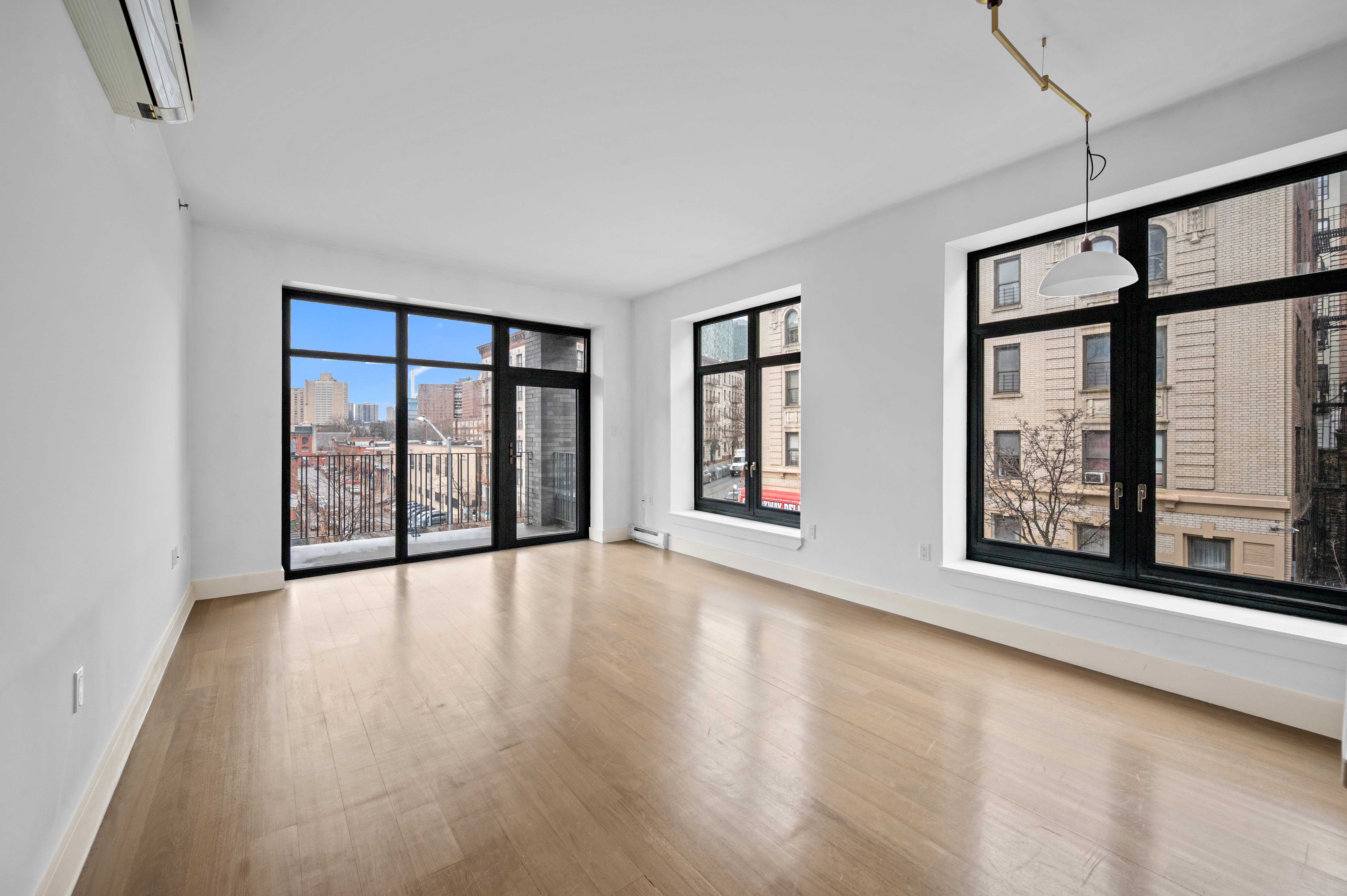 17 Convent Avenue Manhattan, NY 10027 - Photo 2 of 15 a view of an empty room with a window and wooden floor