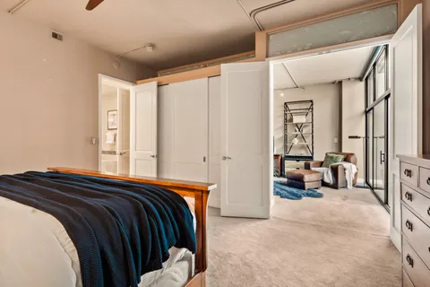 a bedroom with a bed and glass walk in closet