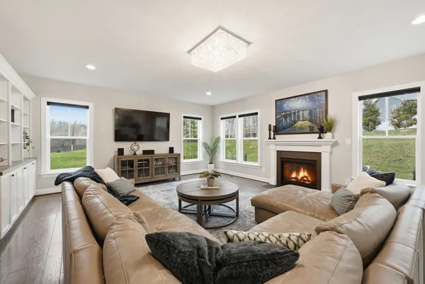 a living room with furniture a fireplace and a large window