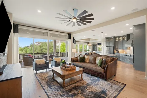 a living room with furniture a large window and a chandelier