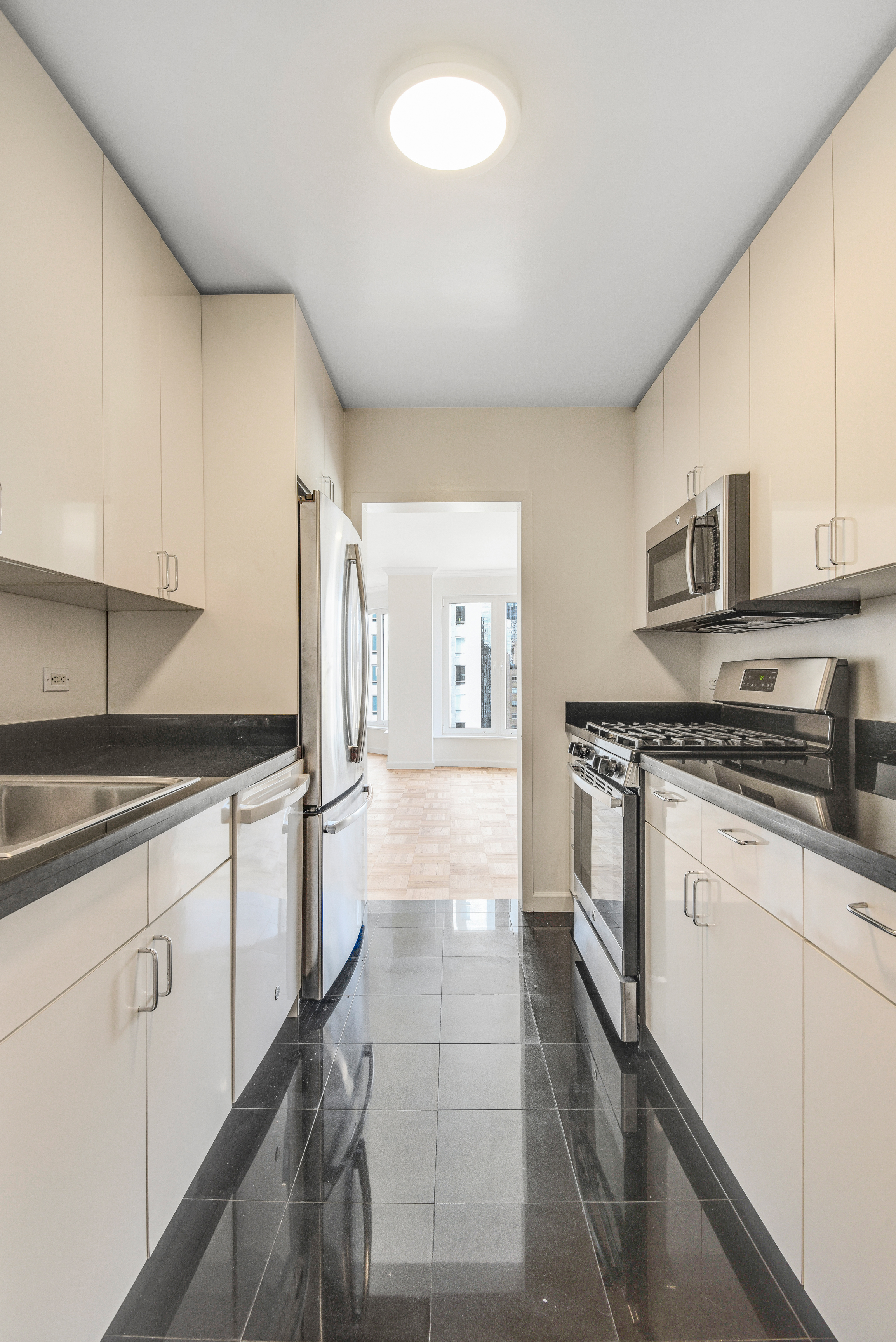 200 Central Park South, Unit 29C Manhattan, NY 10019 - Photo 22 of 23 a kitchen with stainless steel appliances granite countertop a stove a sink and a refrigerator